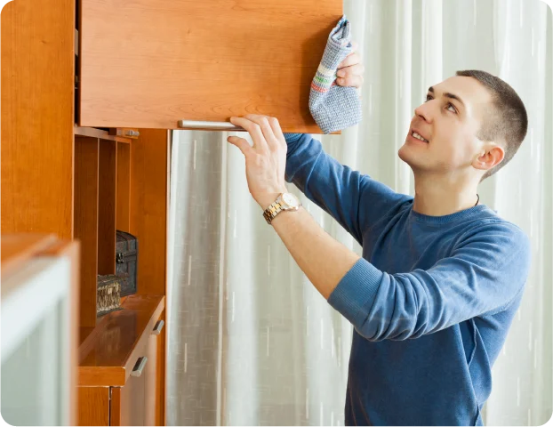 person cleaning their cabinets